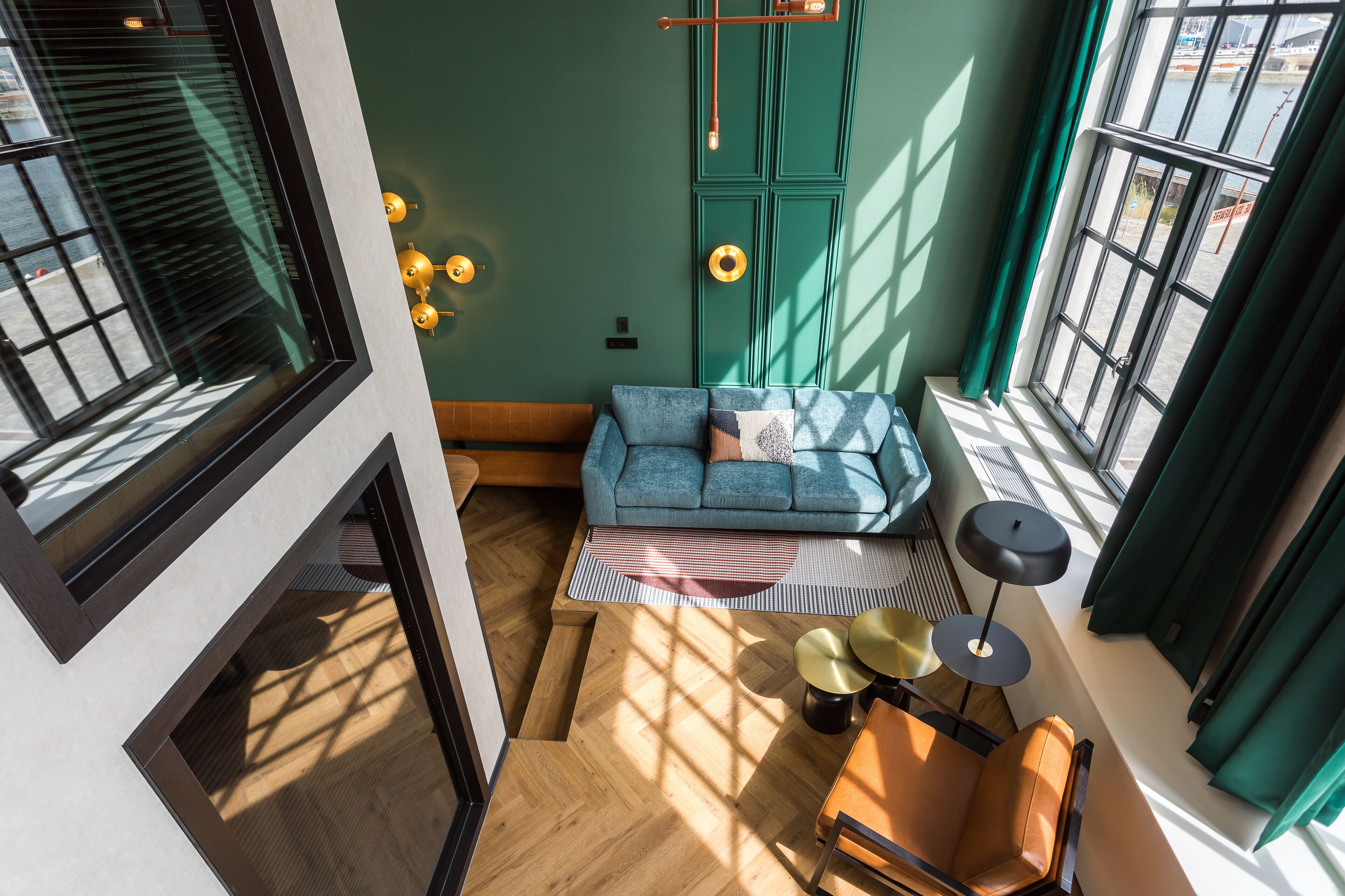 A modern living room with a blue sofa, a small table, and a floor lamp.