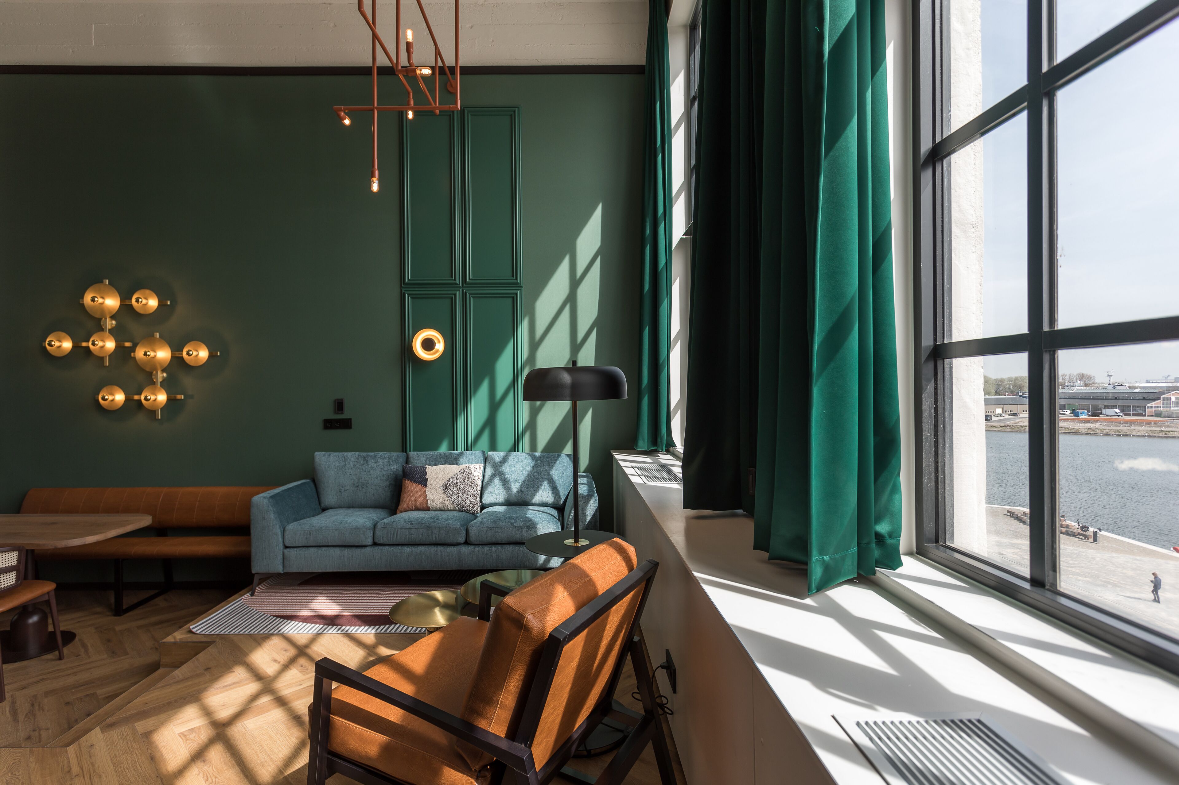 Una sala moderna con sofá, sillón y mesa de comedor.