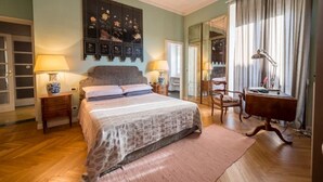 A bedroom with a bed, two bedside tables, a desk, a chair, and a large mirror. - Lovely apartment with furnished terrace (Torino)