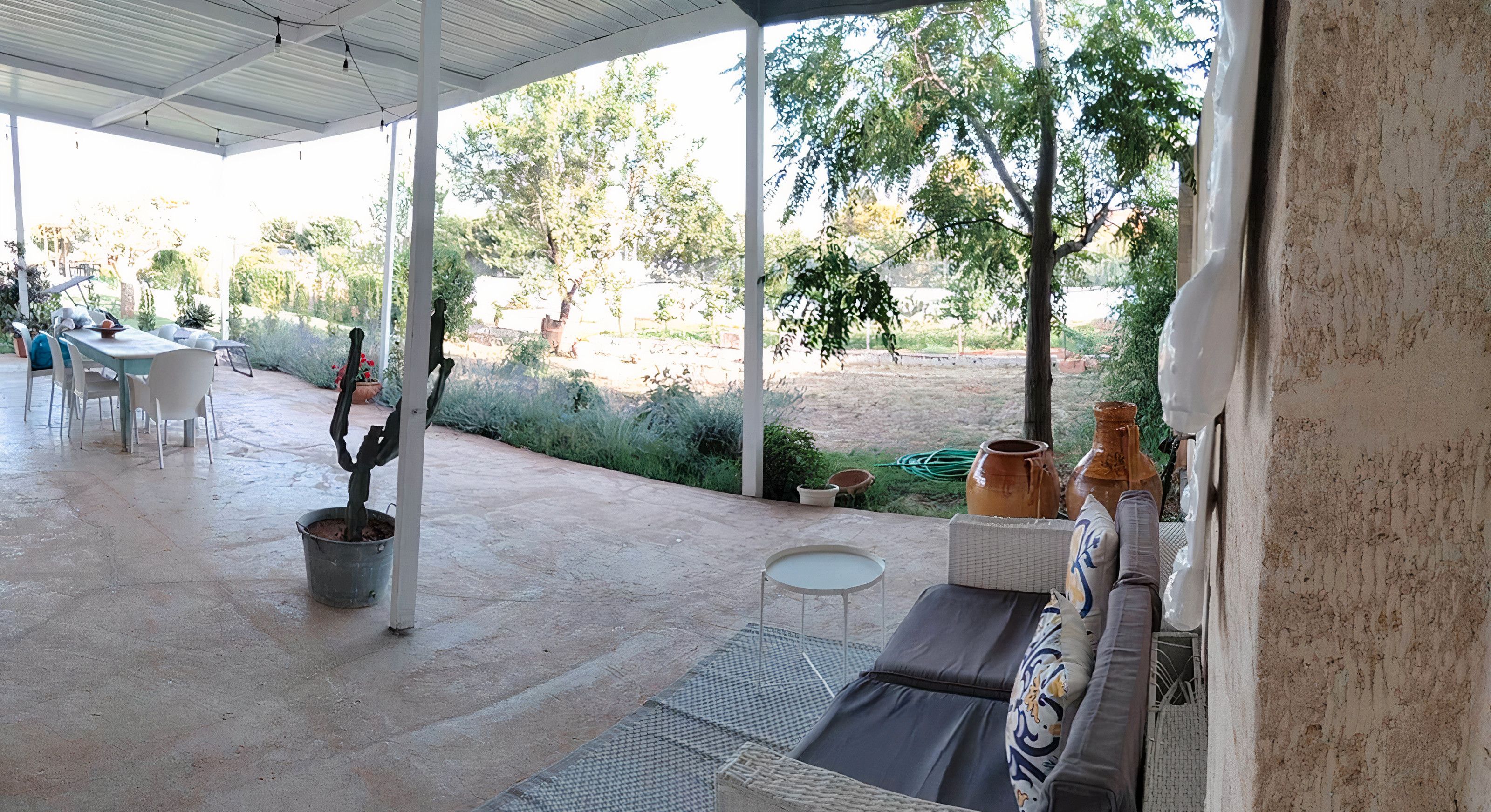 Une terrasse extérieure dotée d’un espace salon abrité, d’une table à manger et de chaises.