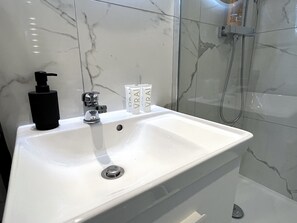 Shower, hair dryer, towels, toilet paper