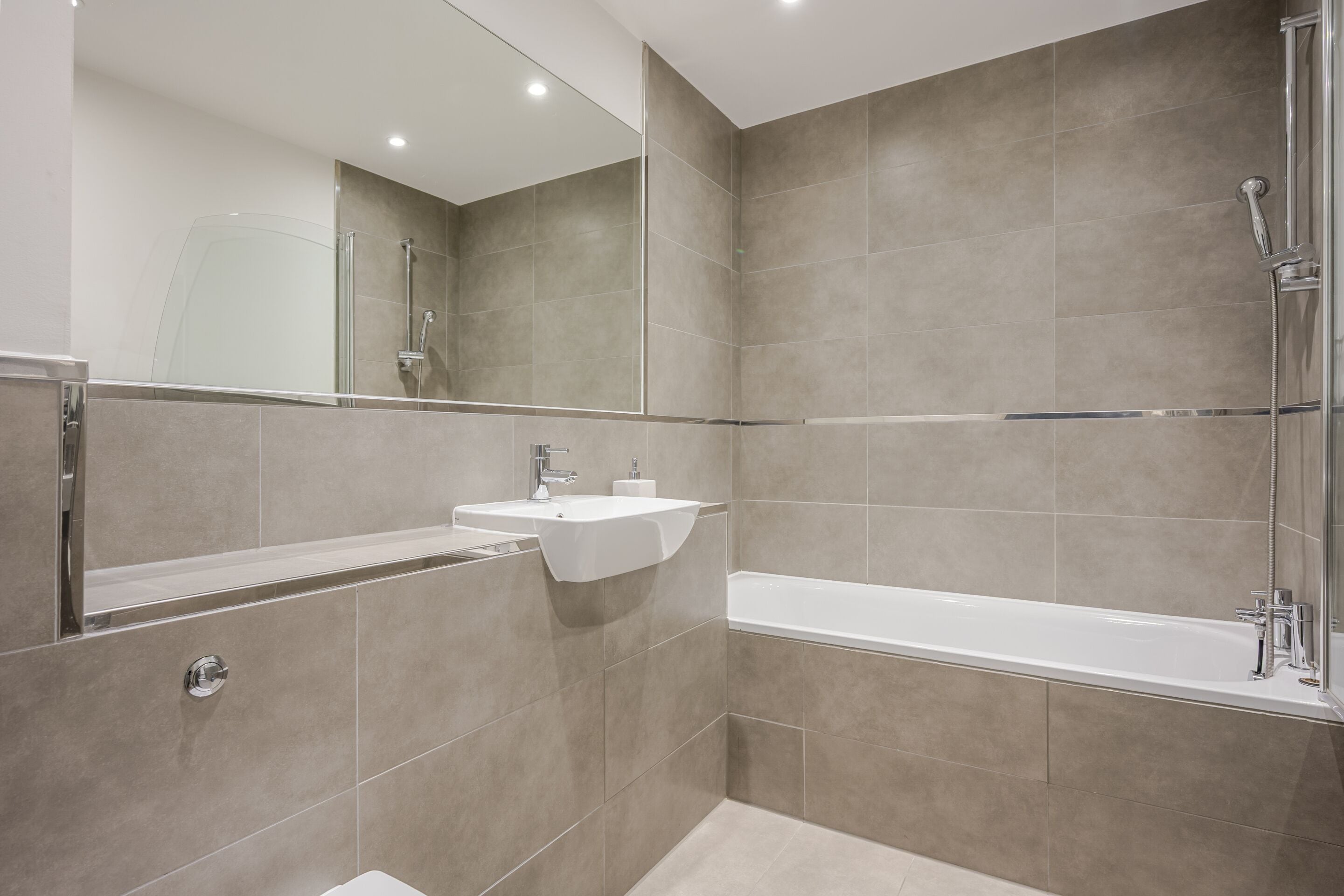 A modern bathroom with a bathtub, a shower, and a sink.
