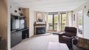 Ein Wohnzimmer mit Kamin, Fernseher und einer gemütlichen Sitzecke.