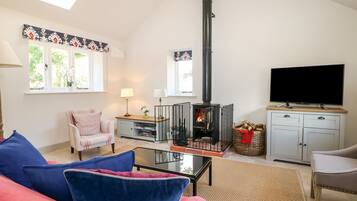 A cozy living room with a fireplace, a television, and comfortable seating.
