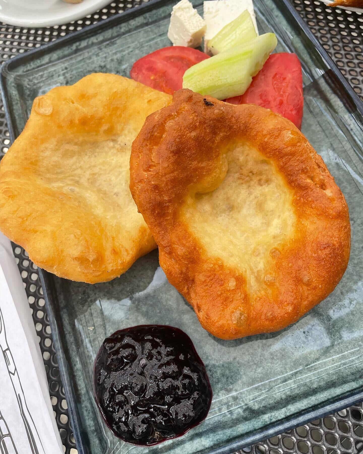 Duas iguarias fritas num prato com legumes e um molho escuro.