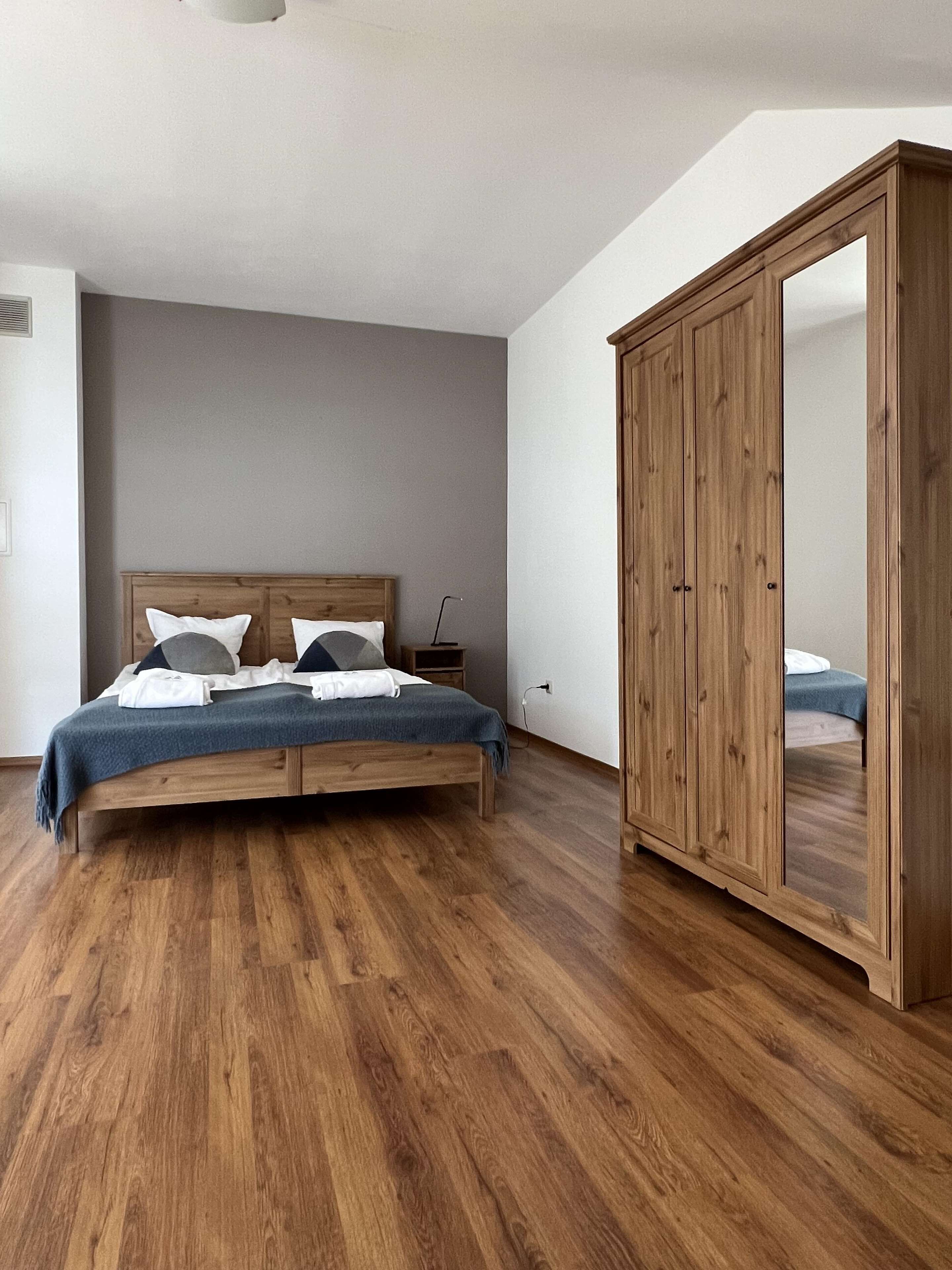 Une chambre à coucher avec un lit en bois, une armoire et une table de chevet.