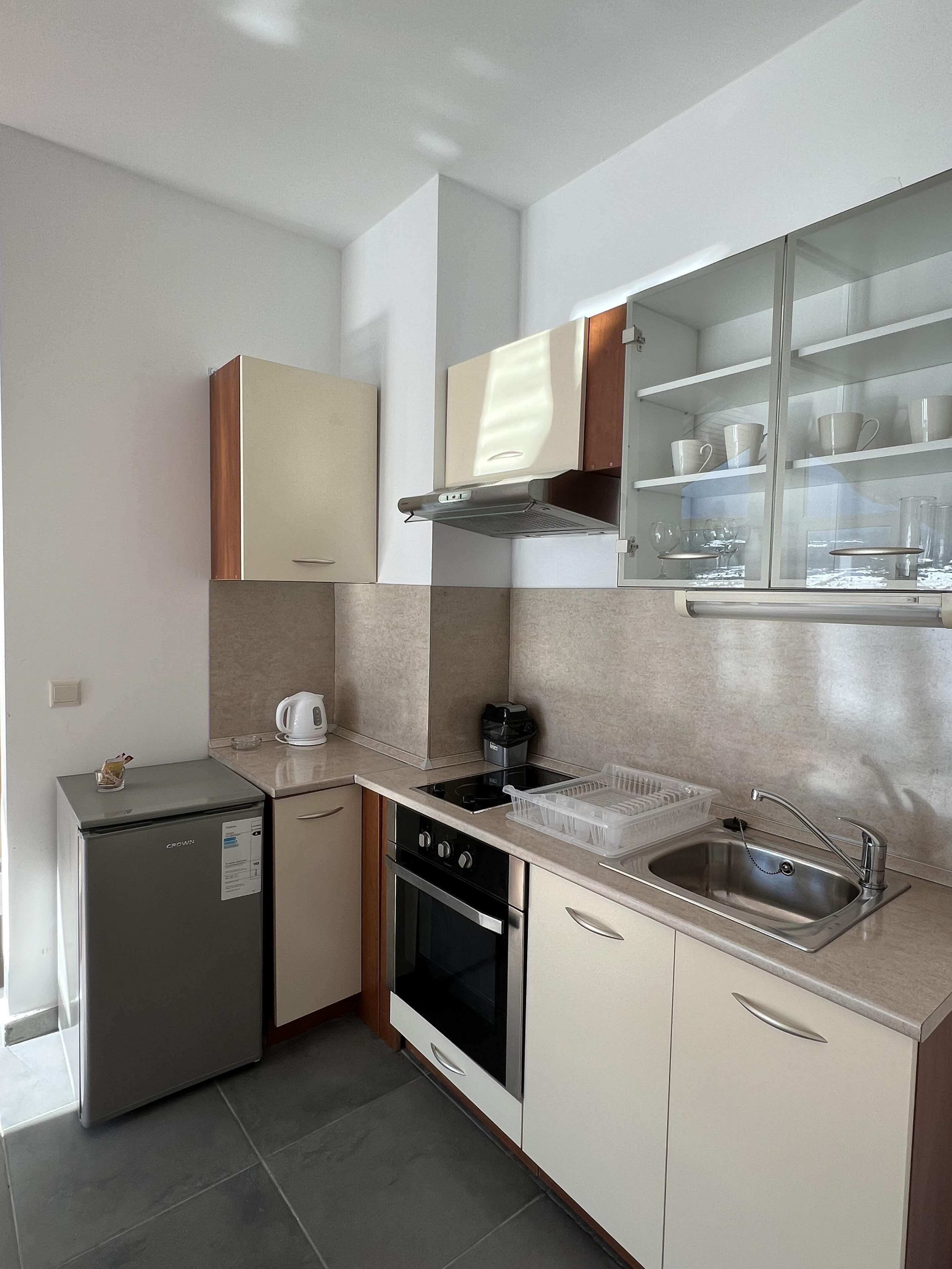 A compact kitchen with a refrigerator, oven, and built-in microwave.