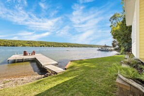A lakeside property with a dock, chairs, and a gazebo.