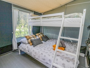 A bunk bed with a ladder, two pillows, and a blanket.