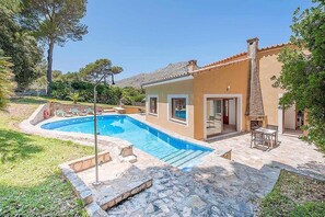 A house with a swimming pool, stone patio, and a stone fireplace. - Casa Alexa, Strandnähe, Pool, Klimaanlage, Wifi, Ruhige Lage (Cala Sant Vicenç)