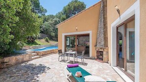 A modern outdoor patio with a pool, lounge chairs, and a stone-tiled floor. - Casa Alexa, Strandnähe, Pool, Klimaanlage, Wifi, Ruhige Lage (Cala Sant Vicenç)