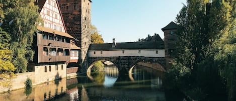 A historic bridge over a river, flanked by traditional half-timbered buildings.