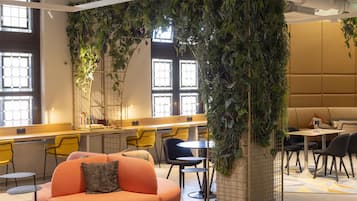A modern indoor space with a seating area, a counter, and a large wall of greenery.