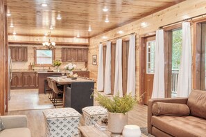 A log cabin interior with a kitchen, dining area, and living room. - Bluestem & Bluebell by AvantStay | Incredible Views w/ Balcony & Indoor Pool! (Sevierville)