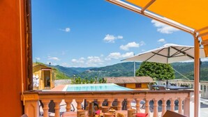 Une table offrant une vue sur les montagnes, une piscine et la rambarde d’un balcon.