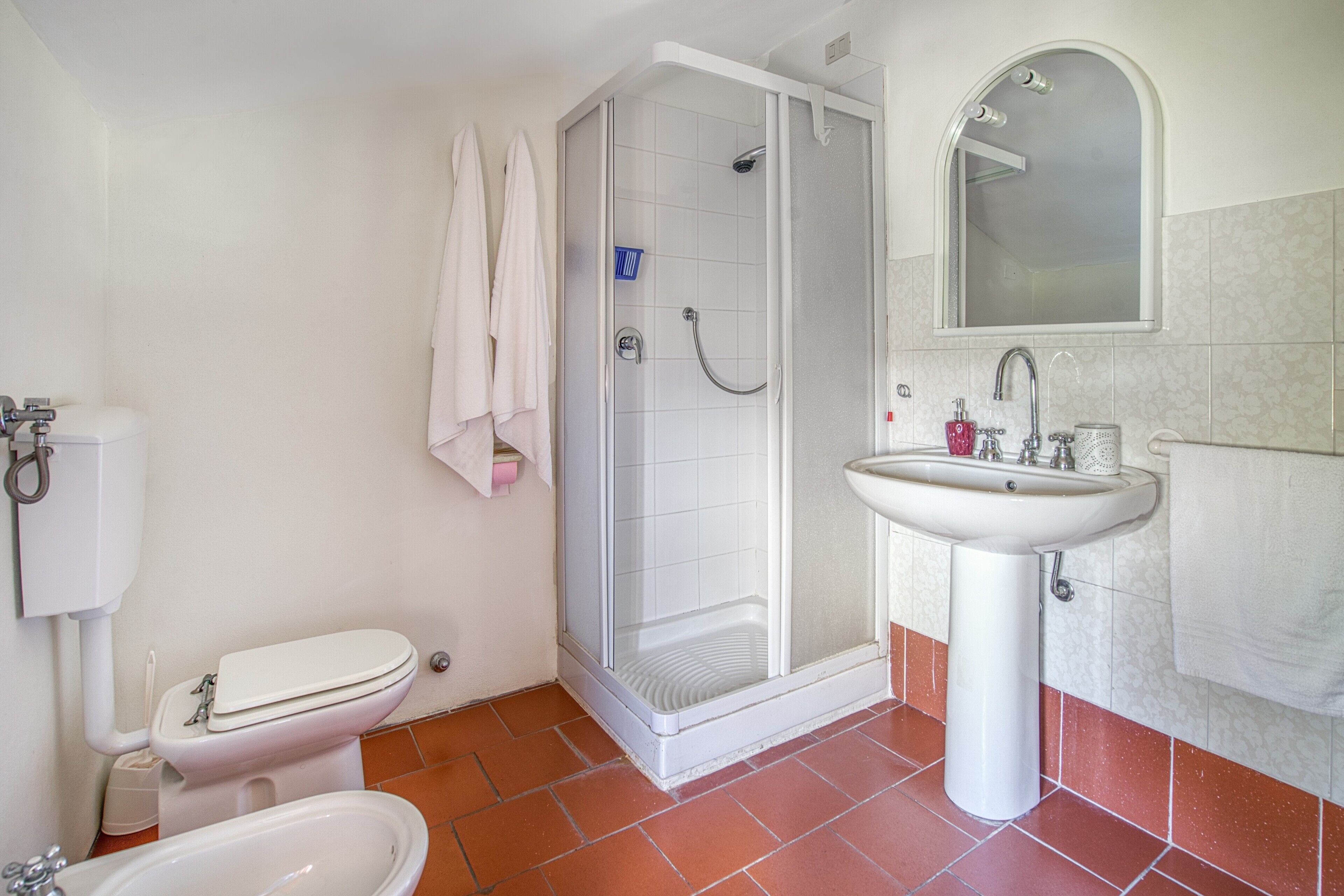 Une salle de bain comprenant des toilettes, un bidet, une douche et un lavabo.