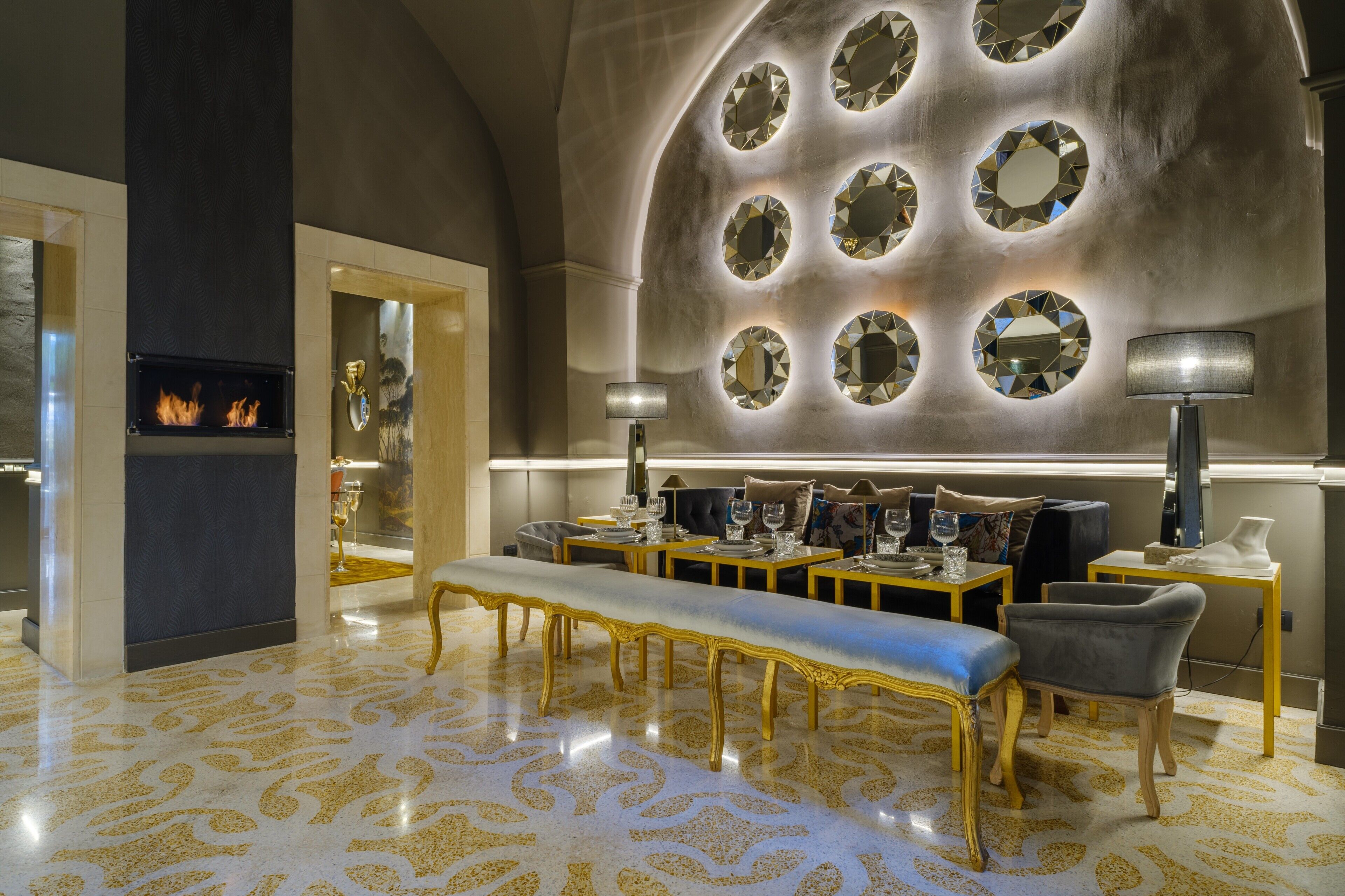 A luxurious interior with a fireplace, ornate mirrors, and elegant furniture.