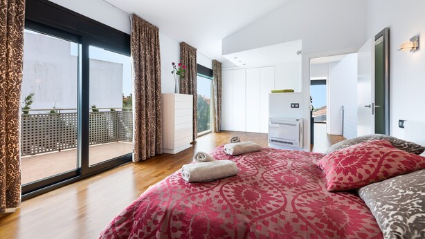 A modern bedroom with a large bed, a balcony, and a view of the outdoors. - Holiday Home 'Villa La Primera' with Shared Pool & Wi-Fi (Llucmajor)