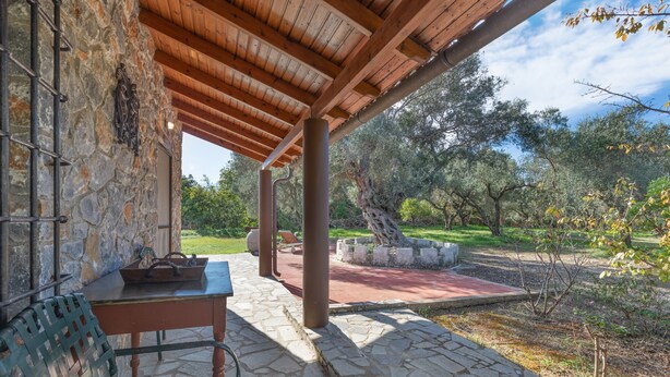 A stone patio with a wooden pergola, outdoor seating, and a view of the surrounding landscape. - Stone house among trees with private garden, terrace & Wi-Fi (?ea? ??d???a?)