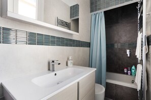 Banheira, secador de cabelo, toalhas de banho 