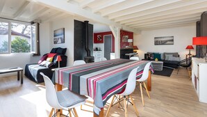 Ein modernes Wohnzimmer mit Essbereich, einer Couch und einer Küche im Hintergrund.