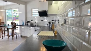 Una cocina moderna con armarios blancos, encimera negra y un tazón verde aguamarina.