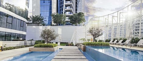 Una piscina al aire libre, sombrillas