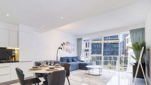 A modern apartment with a dining area, kitchen, and living space with large windows. - LUX - The Pad Executive Suite 4 (Dubai)