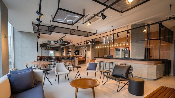 A modern bar area with seating and a counter. - Ibis Guarapuava (Guarapuava)