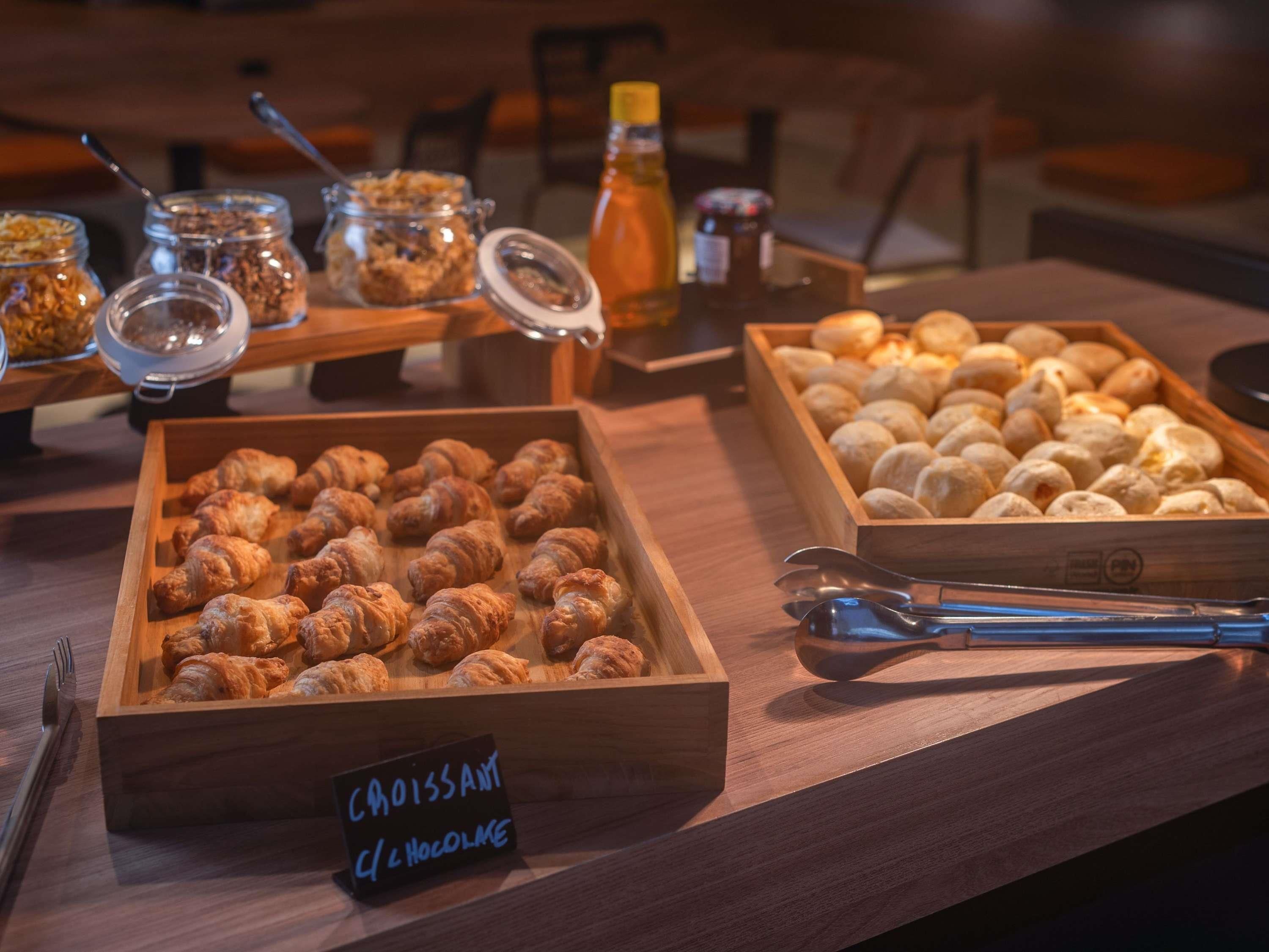 A buffet with various food items including croissants and bread rolls.
