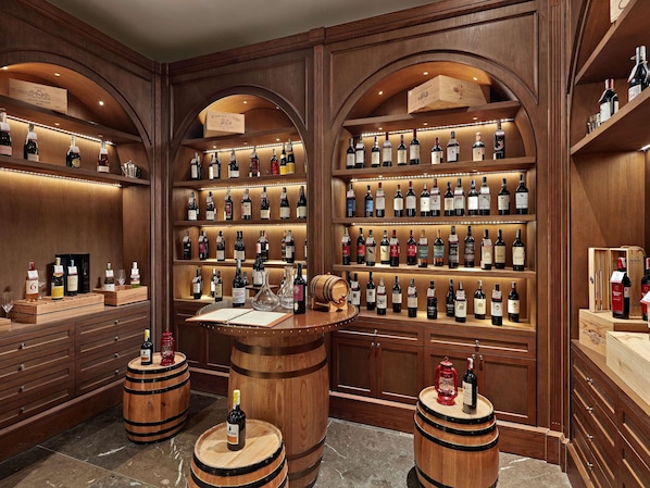 Una cantina vinicola con scaffali e botti di legno, con una varietà di bottiglie di vino.