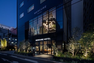 L’extérieur de l’hôtel Mercure, avec son enseigne lumineuse et sa façade moderne.