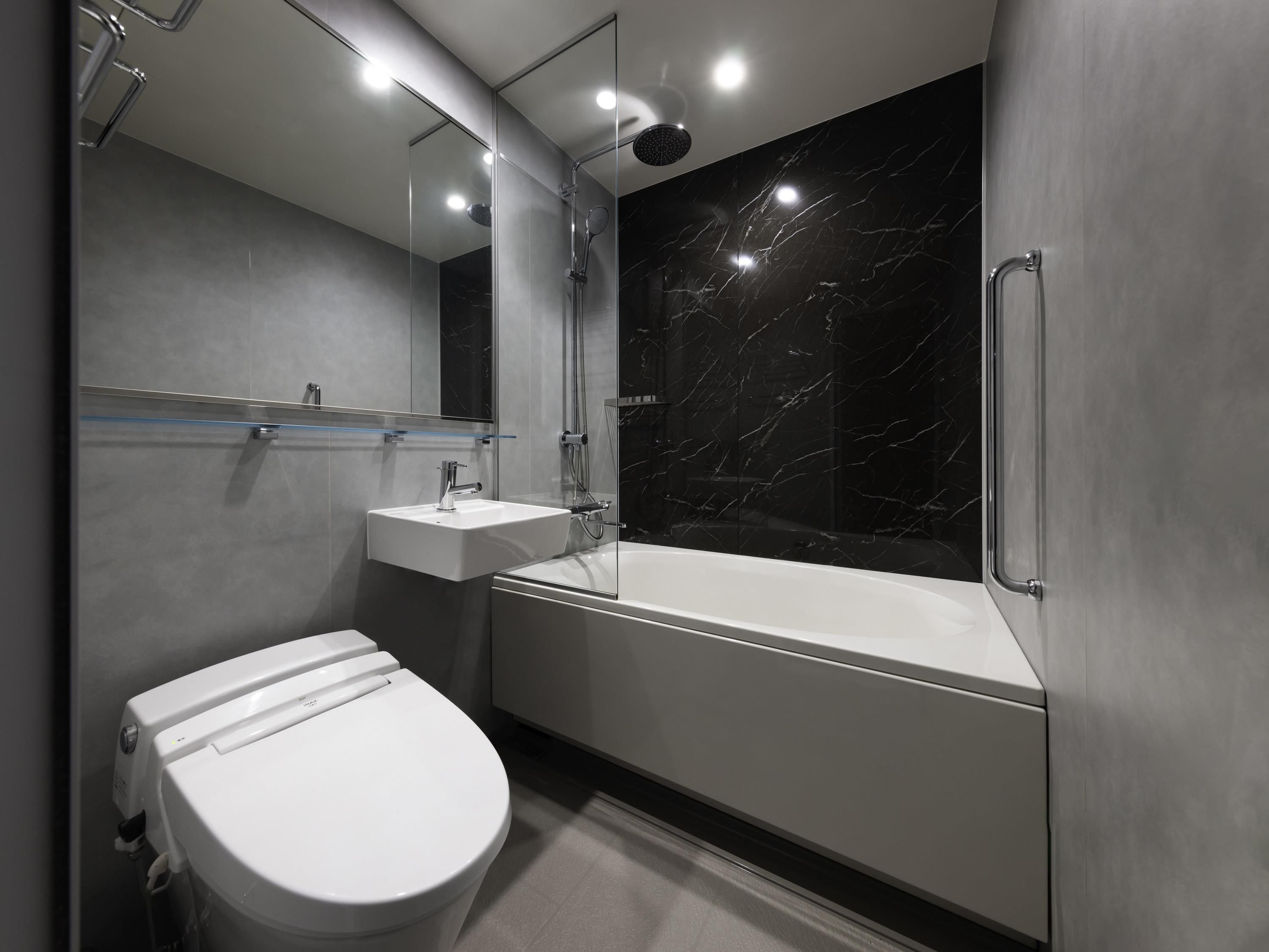 A modern bathroom with a toilet, sink, and bathtub.