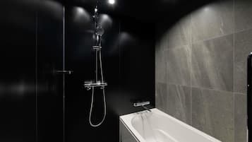 Un bagno moderno con una vasca, una doccia con soffione manuale e un rubinetto a parete.