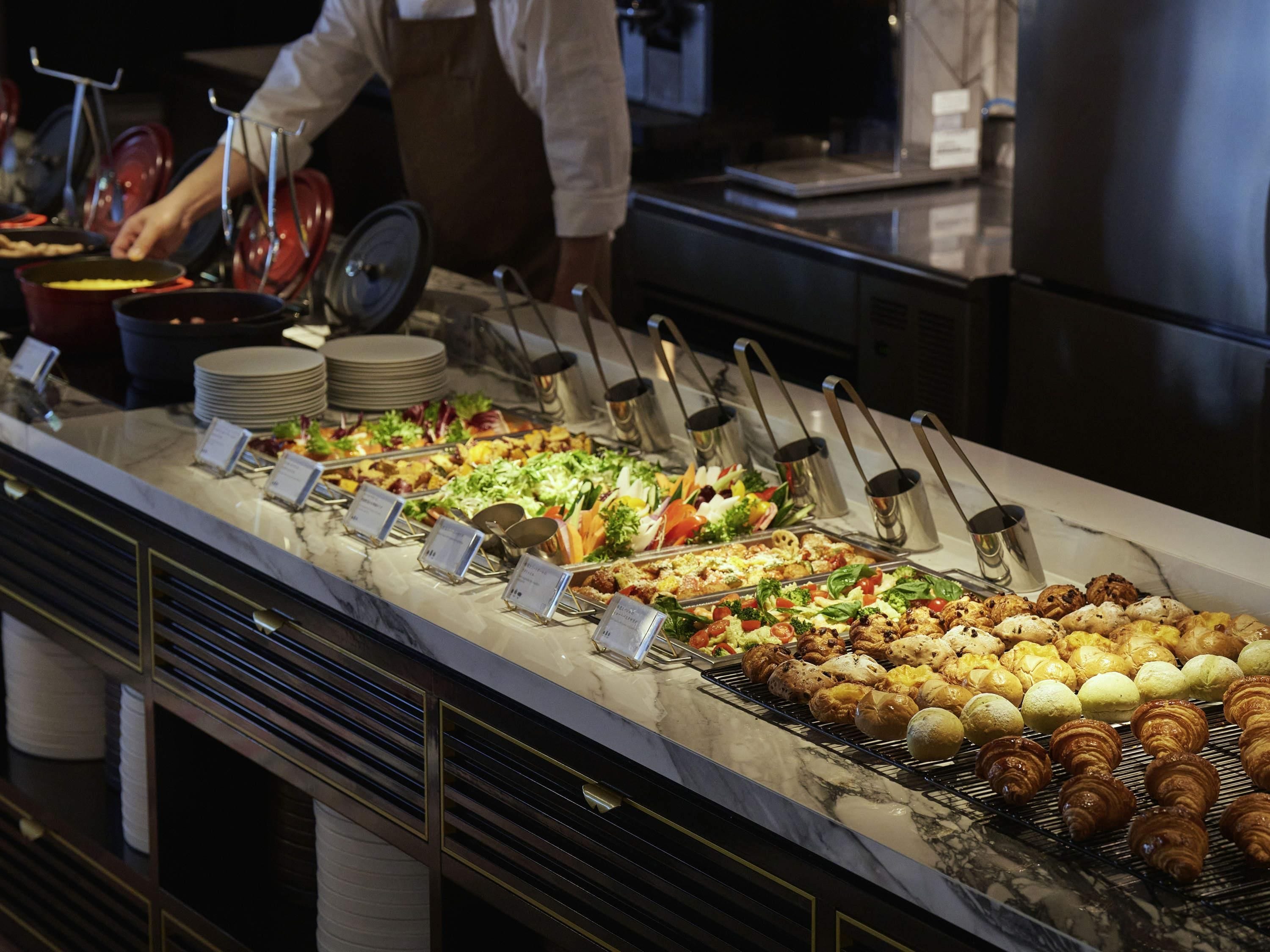 A buffet with various food items and utensils.