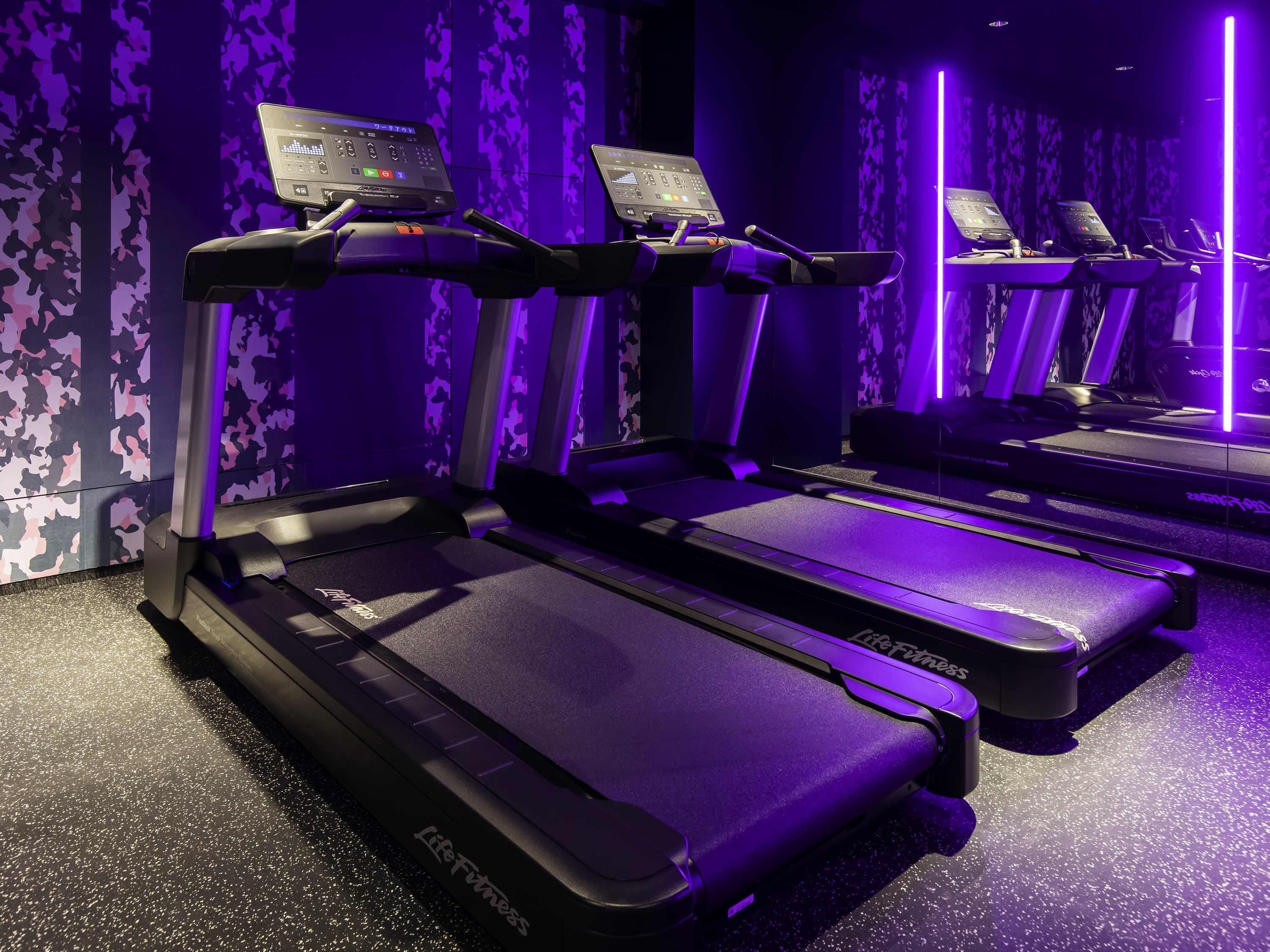 A fitness area with treadmills and a mirrored wall.