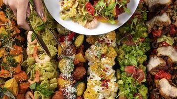 A variety of dishes including pasta, shrimp, and vegetables.