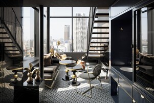 A modern interior with a city view, featuring a sofa, a round table, and a chair.