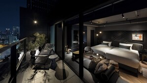 A modern bedroom with a large bed, a seating area with a coffee table, and a balcony with potted plants. - Mercure Tokyu Stay Osaka Namba (Osaka)
