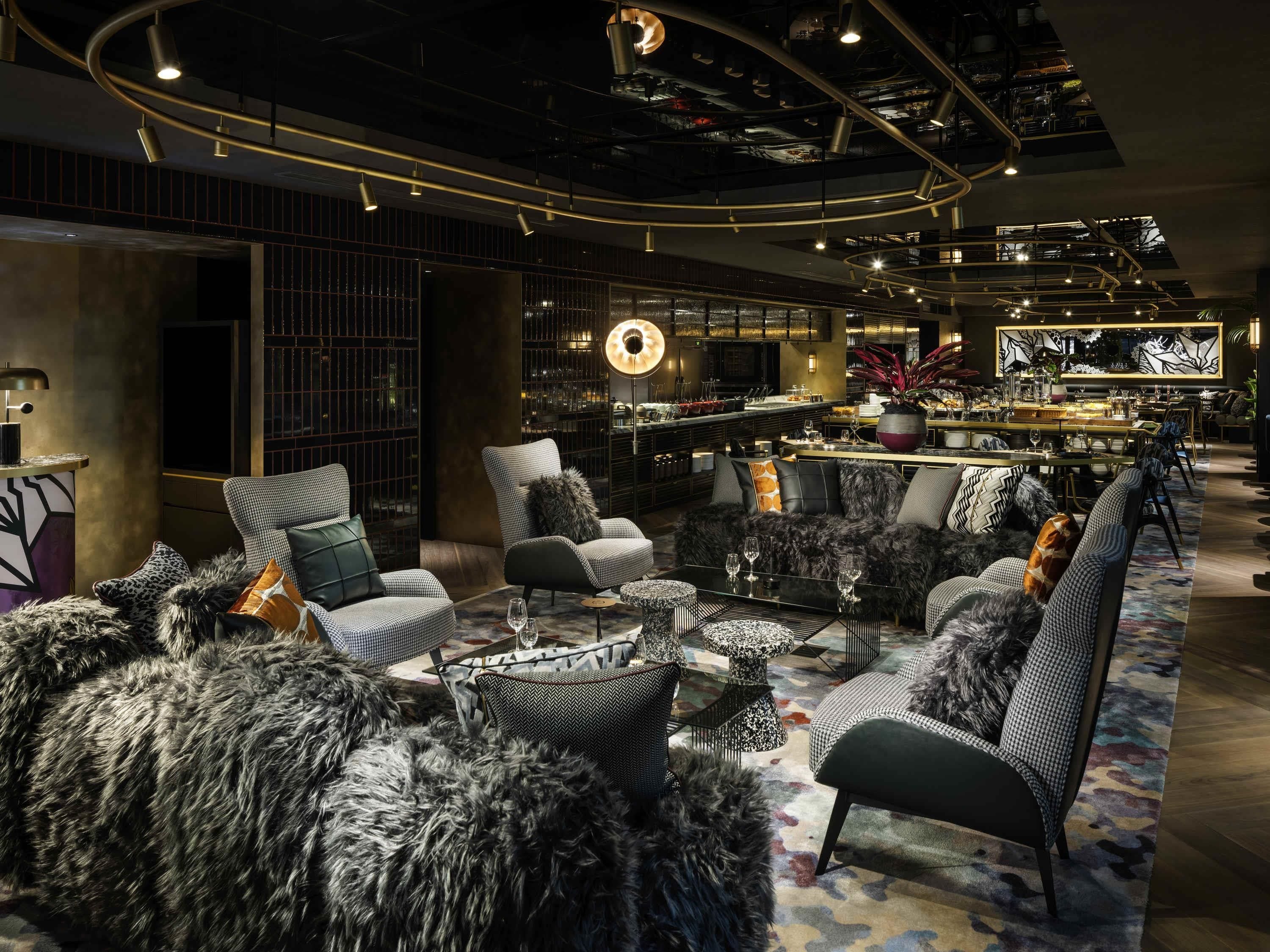 Un intérieur moderne comprenant un ensemble de canapés, un coin bar et un espace repas.