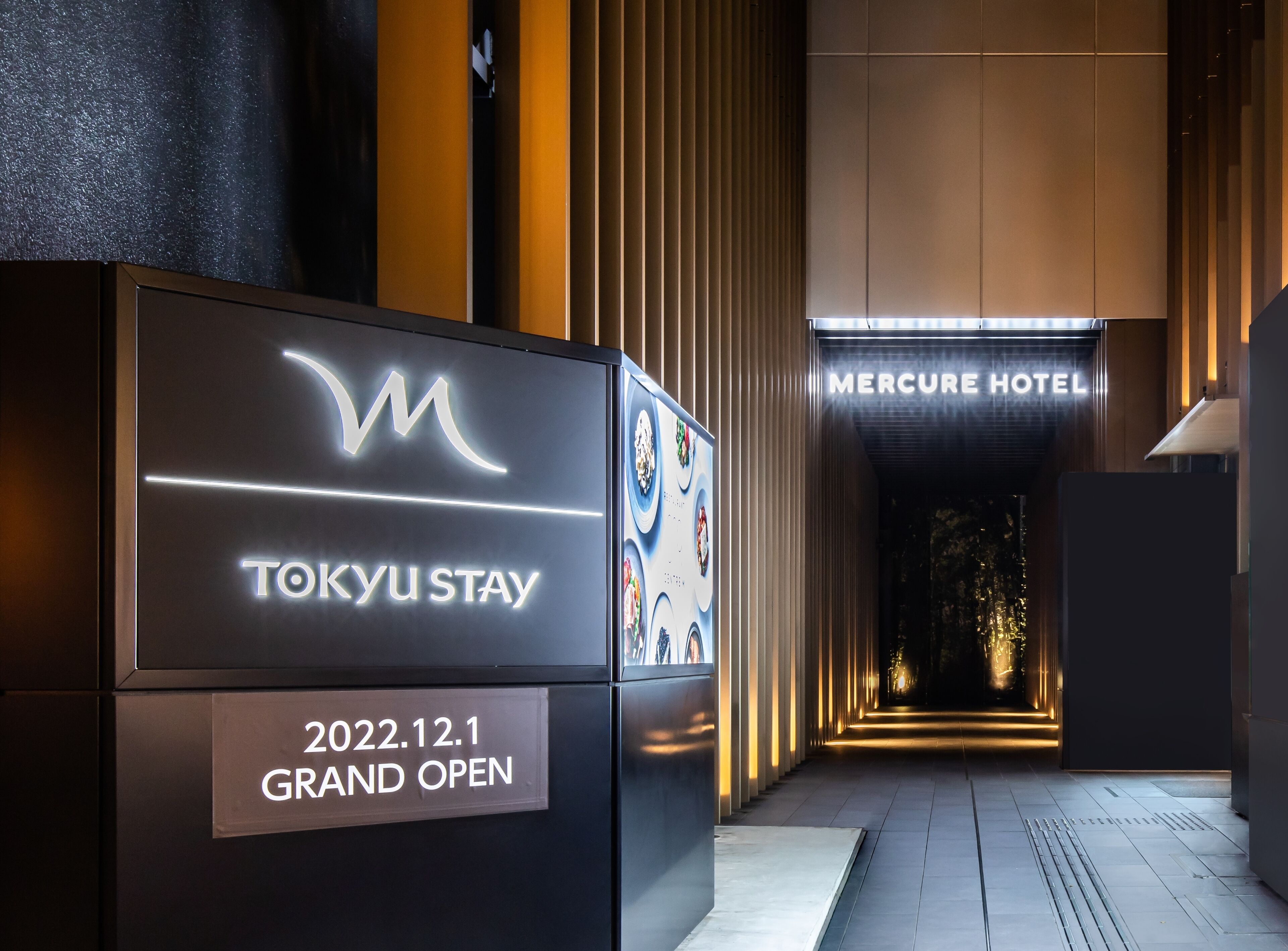 TOKYU STAY -kyltti, jossa ilmoitetaan hotellin avajaispäiväksi 1.12.2022, sekä MERCURY HOTEL -hotellin sisäänkäynti.