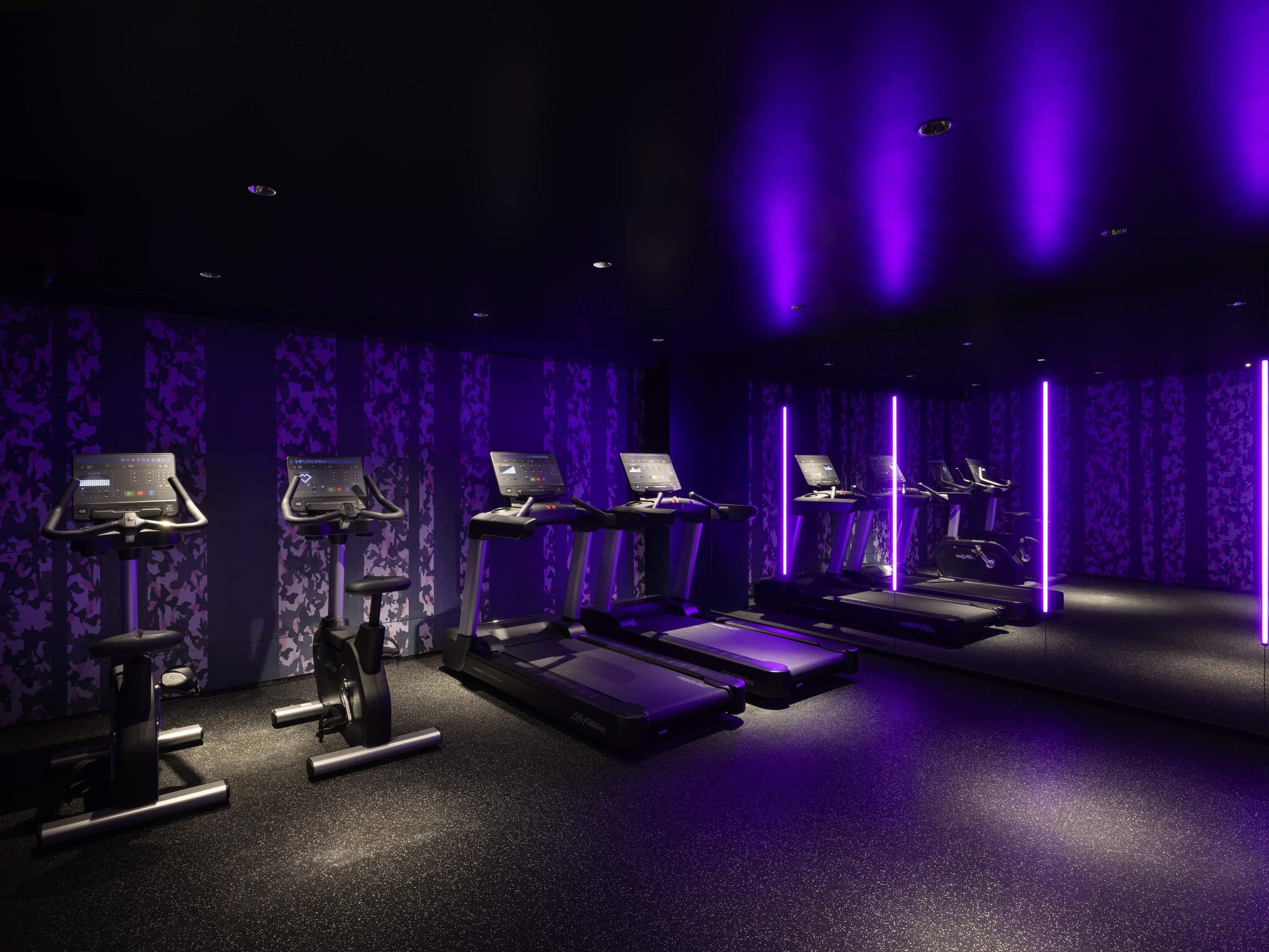 A gym with treadmills, elliptical machines, and weight benches.