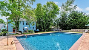 A rectangular swimming pool with a metal ladder, surrounded by a stone deck. - Breathtaking Harwich Retreat w/ Heated Pool and Spa RPAM086 (Harwich)
