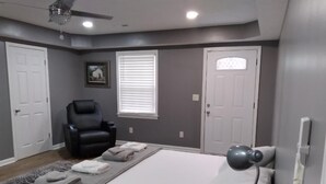 A bedroom with a bed, a chair, a desk, and a ceiling fan. - Home away from home. Relaxing and welcoming stay.  20min from Myrtle Beach. (Conway)