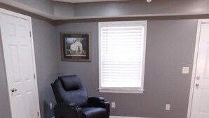 A room with a black leather chair, a patterned rug, a sofa with cushions, and a framed picture on the wall. - Home away from home. Relaxing and welcoming stay.  20min from Myrtle Beach. (Conway)