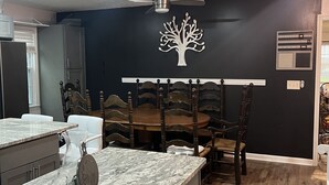 A modern kitchen with a marble countertop, wooden dining table, and chairs. - Home away from home. Relaxing and welcoming stay.  20min from Myrtle Beach. (Conway)