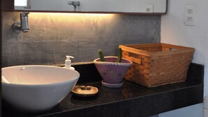 A bathroom with a white sink, a mirror, a wooden basket, and a decorative bowl with a cactus. - COBERTURA DUPLEX COM TERRAÇO EM IPANEMA (Rio de Janeiro)