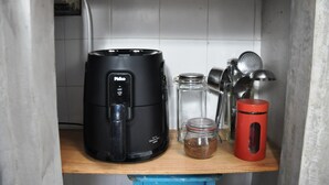 A kitchen area with a coffee maker, a glass jar with a red lid, and various kitchen utensils on a wooden shelf. - COBERTURA DUPLEX COM TERRAÇO EM IPANEMA (Rio de Janeiro)