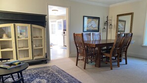 A dining area with a wooden table and chairs, a blue patterned rug, and a cabinet with glass doors. - Beautiful Home in Ontonagon - 2 blocks from Lake Superior (Ontonagon)
