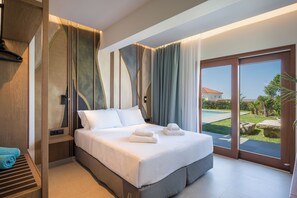 A modern hotel room with a large bed, a view of the garden, and a sliding glass door. - Azatis Luxury Villa: 7-bedroom Villa with a Heated Pool, Hot Tub & Seaview (Chania)